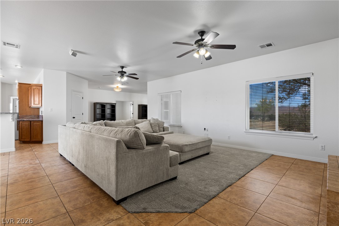 575 Gann Avenue Logandale, NV 89021 - Photo 12 of 75 An inviting open-concept living space features tile flooring and ample natural light, creating an airy atmosphere.