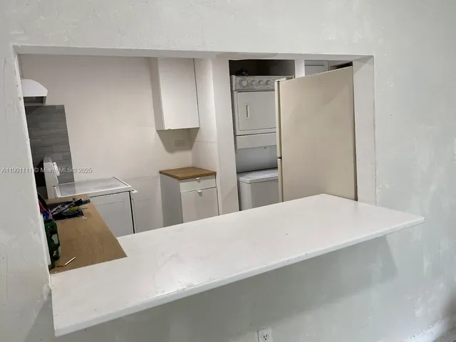 a room with a refrigerator and wooden floor