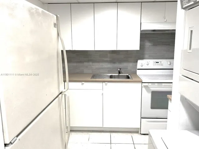 a kitchen with a stove a sink and a refrigerator