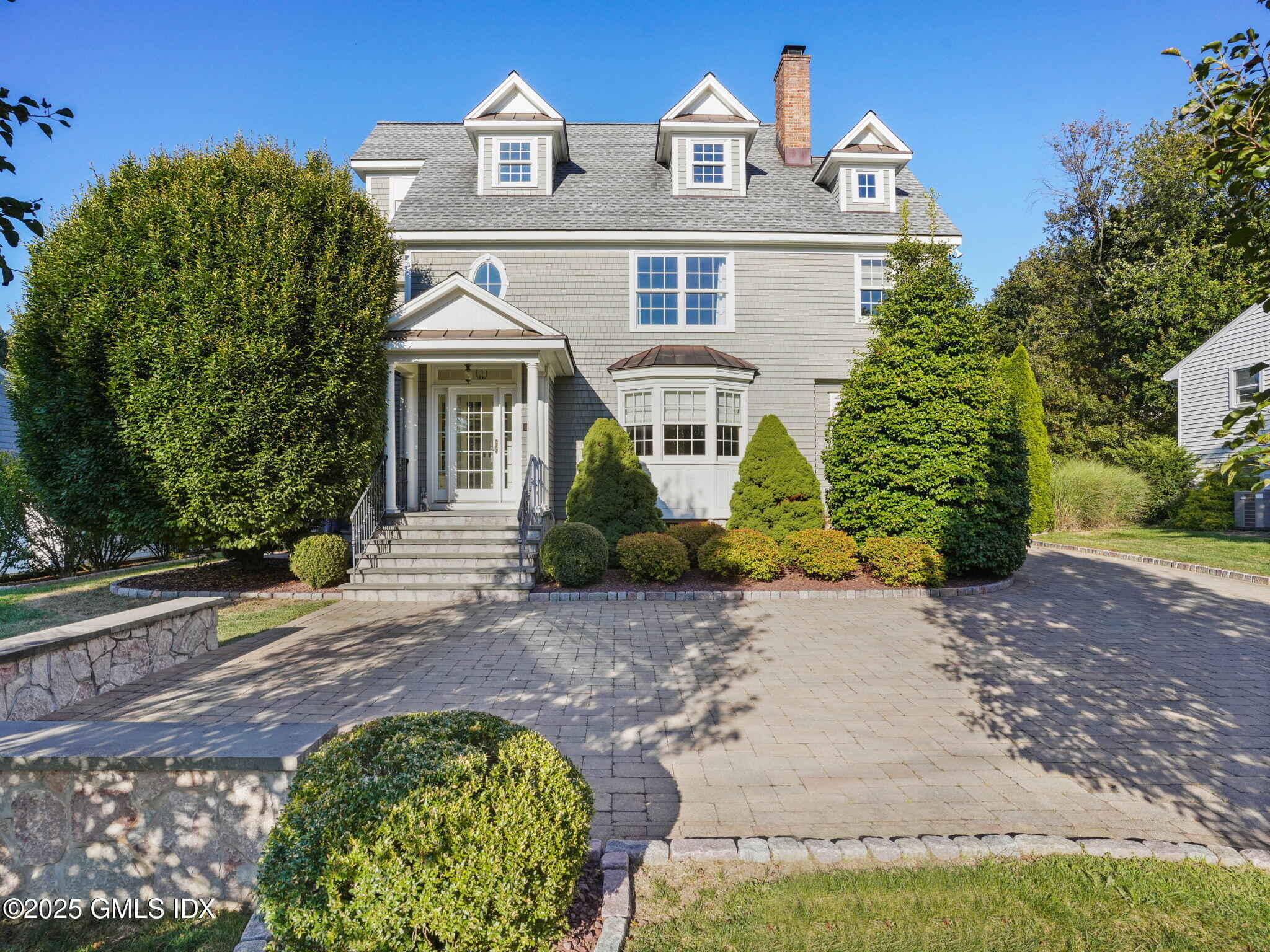 a front view of a house with a garden