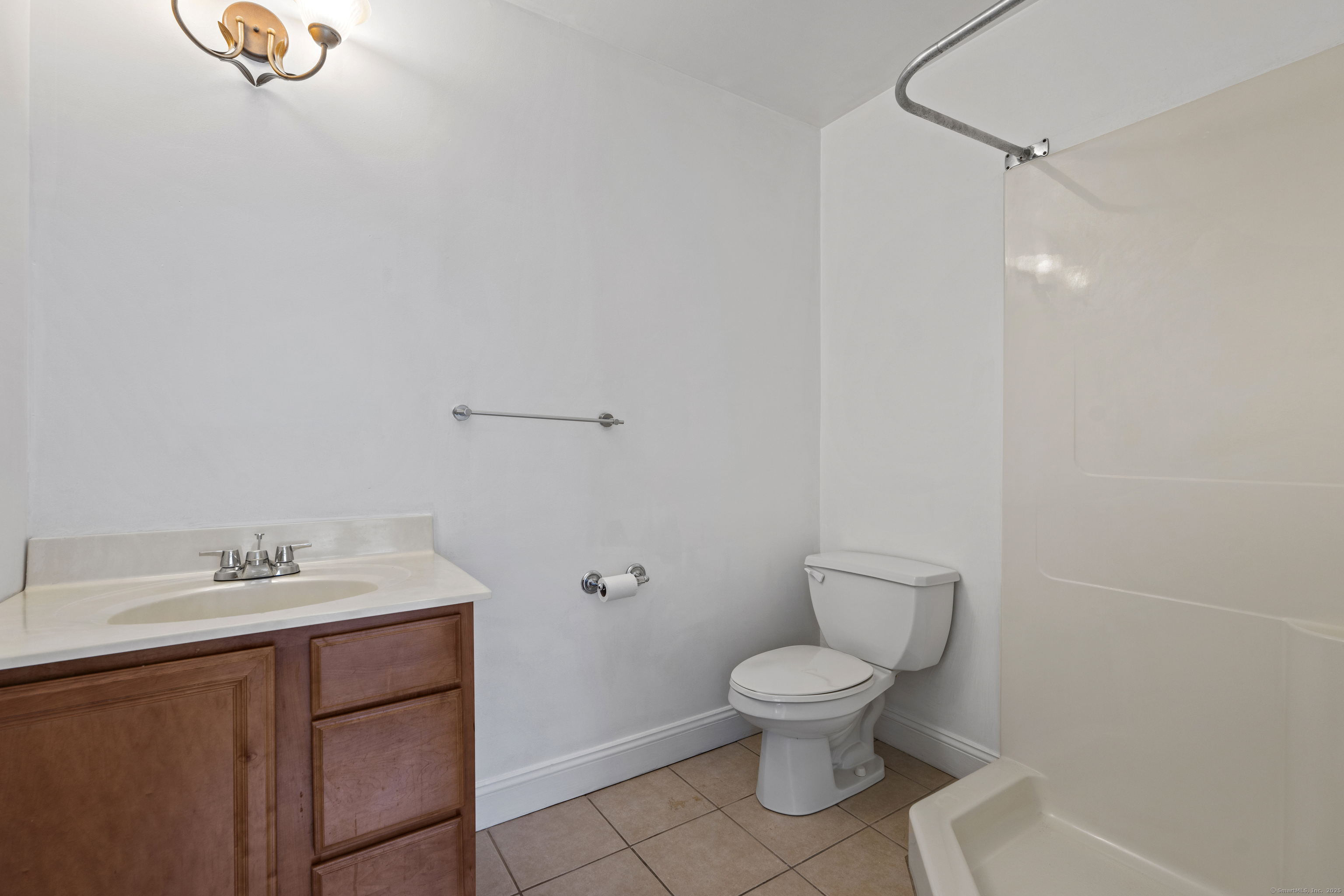 527 West Thames Street, Unit 9 Norwich, CT 06360 - Photo 18 of 25 a bathroom with a toilet sink and mirror