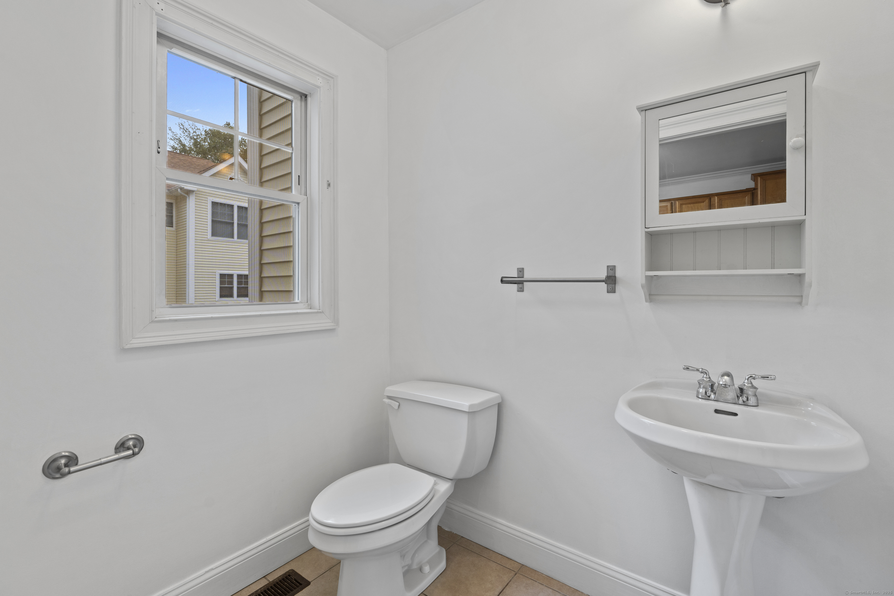 527 West Thames Street, Unit 9 Norwich, CT 06360 - Photo 19 of 25 a bathroom with a toilet sink and mirror