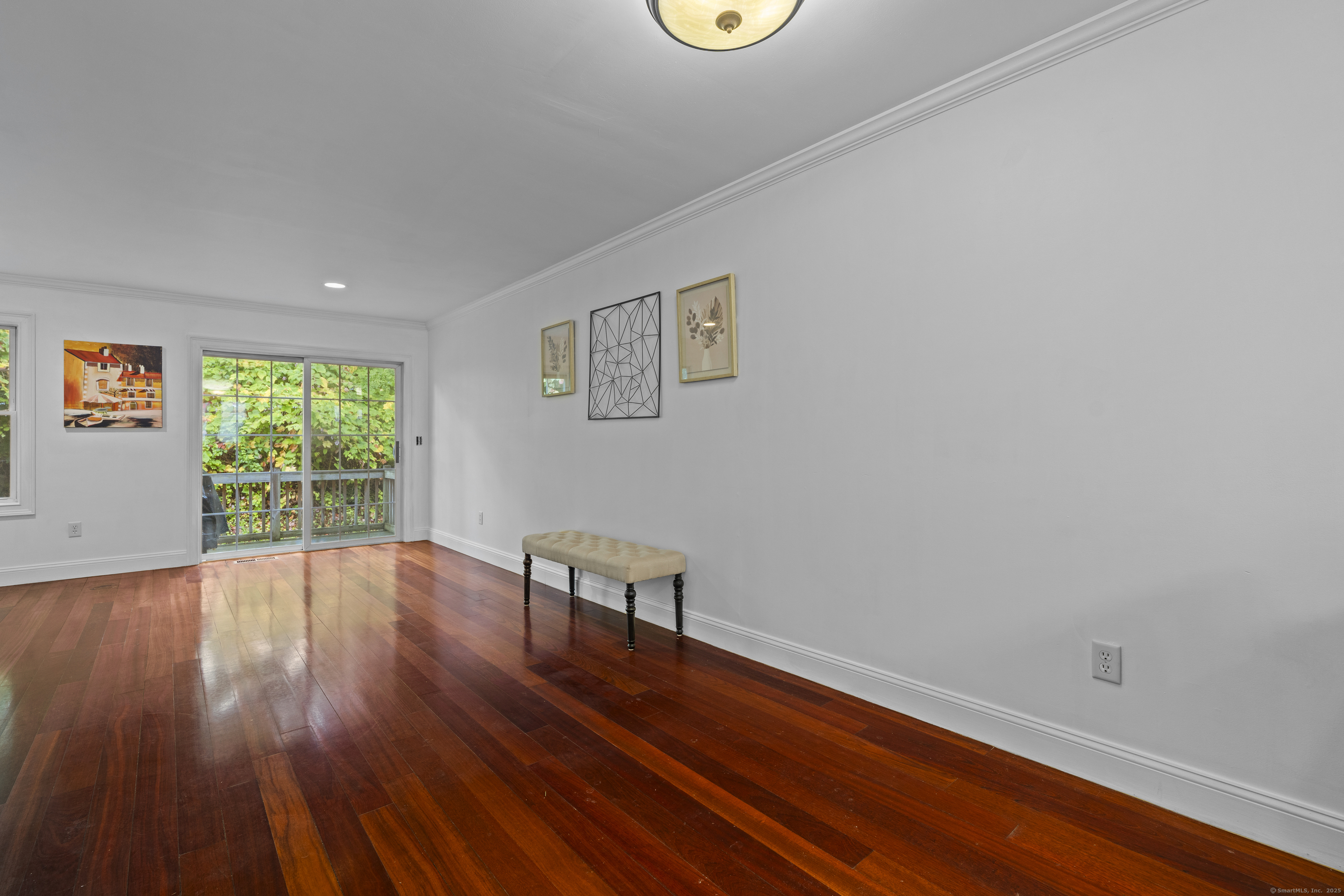 527 West Thames Street, Unit 9 Norwich, CT 06360 - Photo 5 of 25 a view of an empty room with wooden floor and a window