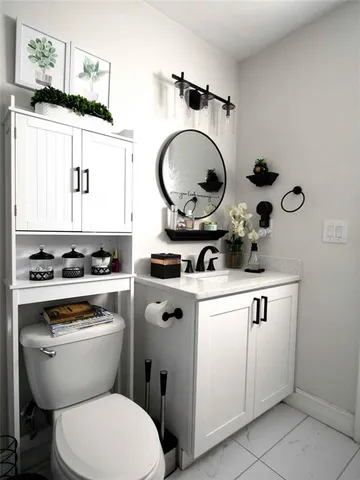 a bathroom with a toilet a sink and a mirror