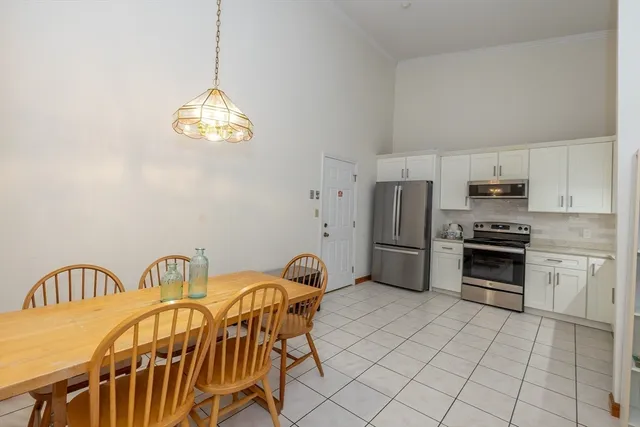 a kitchen with stainless steel appliances a stove a sink dishwasher a dining table and chairs with wooden floor