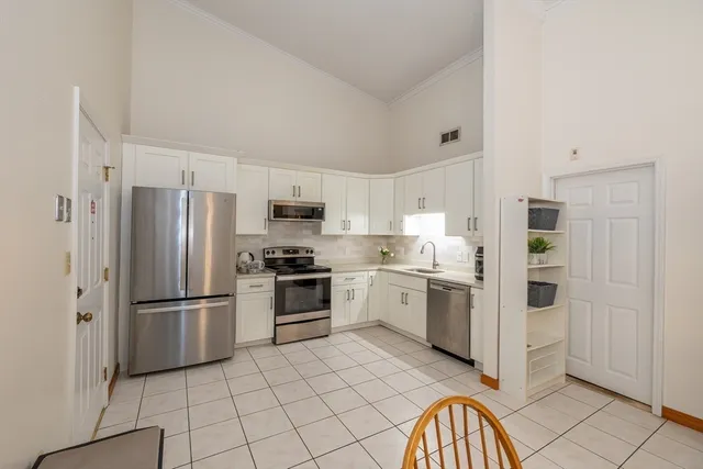 a kitchen with stainless steel appliances granite countertop a refrigerator and a stove top oven