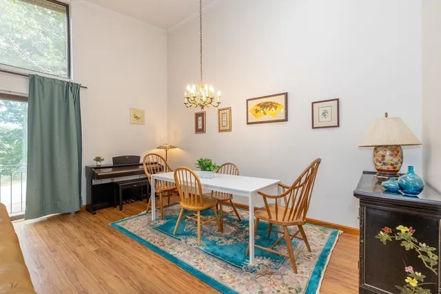 a view of a dining room with furniture a chandelier and wooden floor