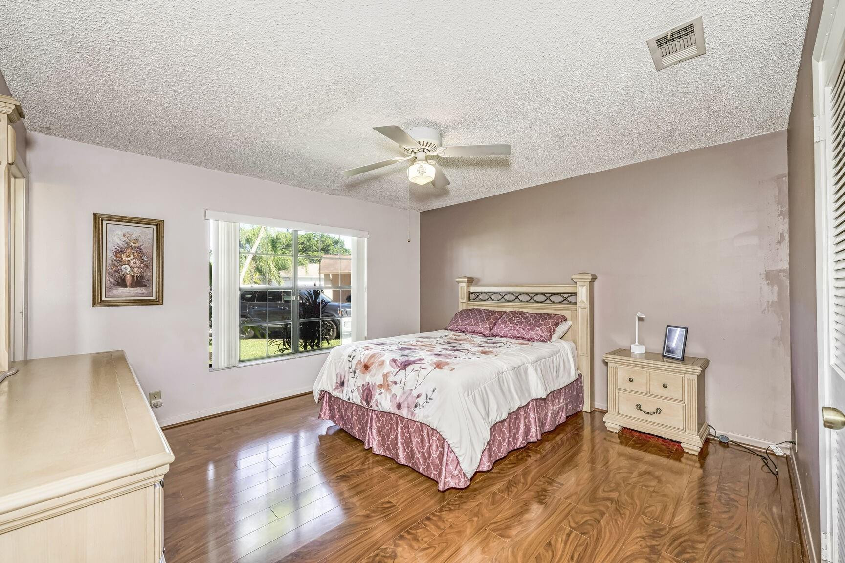 12630 Southwest 13th Manor Davie, FL 33325 - Photo 12 of 22 a bedroom with a bed and a chandelier