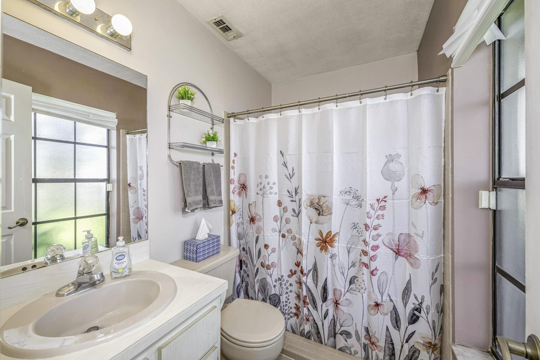 12630 Southwest 13th Manor Davie, FL 33325 - Photo 13 of 22 a bathroom with a sink a toilet and shower curtain