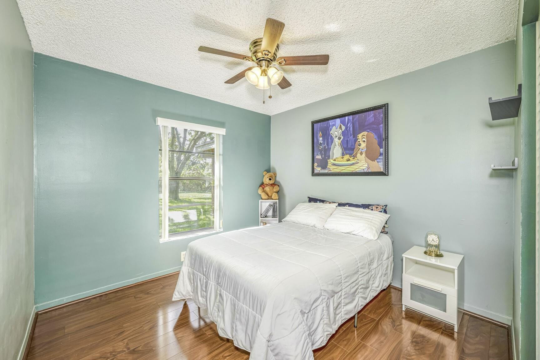 12630 Southwest 13th Manor Davie, FL 33325 - Photo 14 of 22 a bedroom with a bed and a chandelier