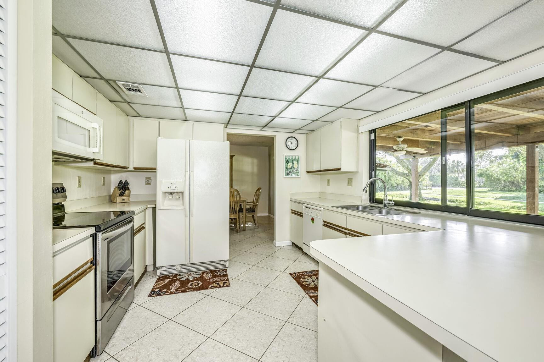 12630 Southwest 13th Manor Davie, FL 33325 - Photo 9 of 22 a kitchen with stainless steel appliances granite countertop a sink stove and refrigerator