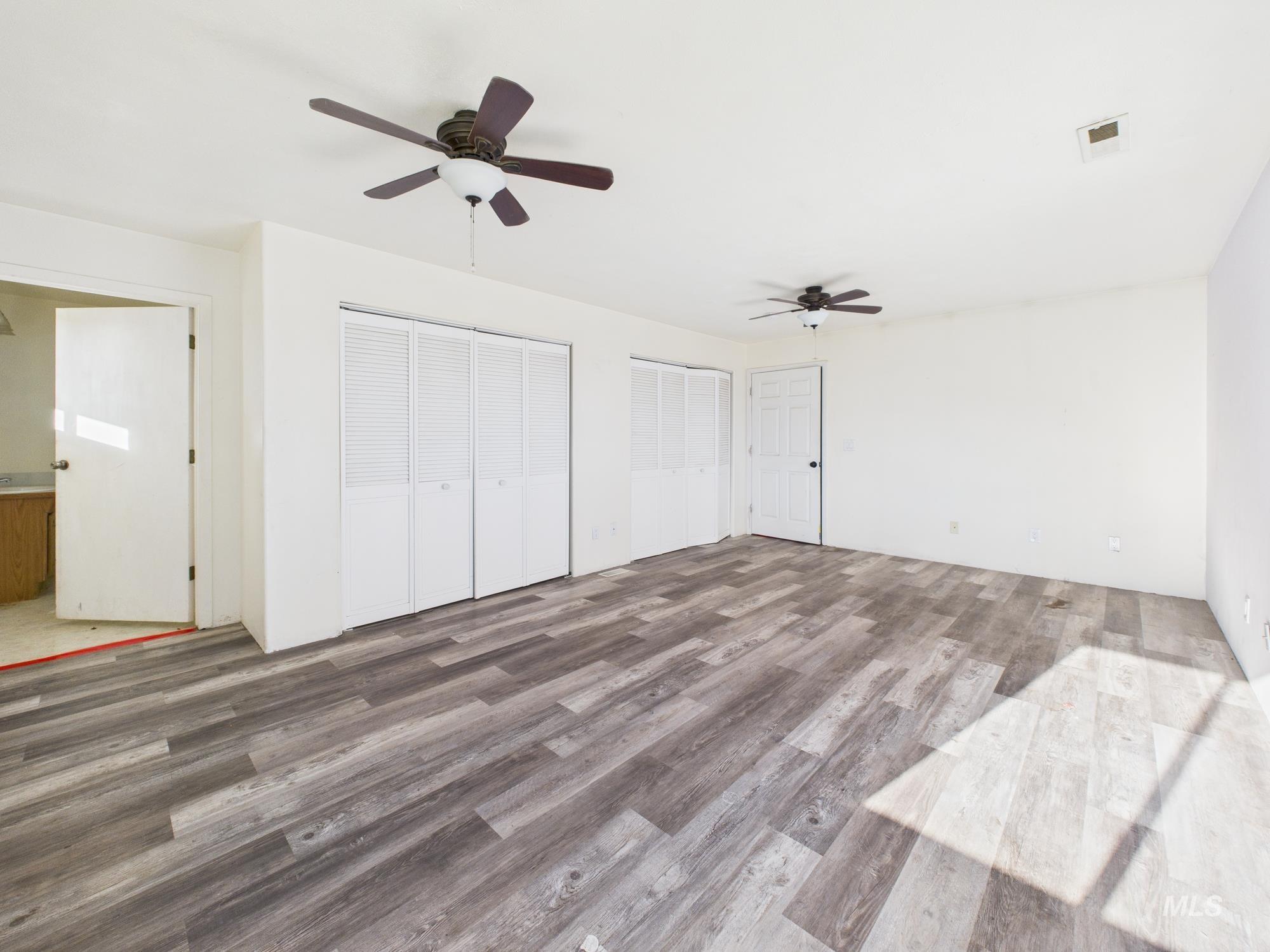 7352 Custer Road Fruitland, ID 83619 - Photo 15 of 43 Unfurnished bedroom with multiple closets, wood finished floors, and ceiling fan