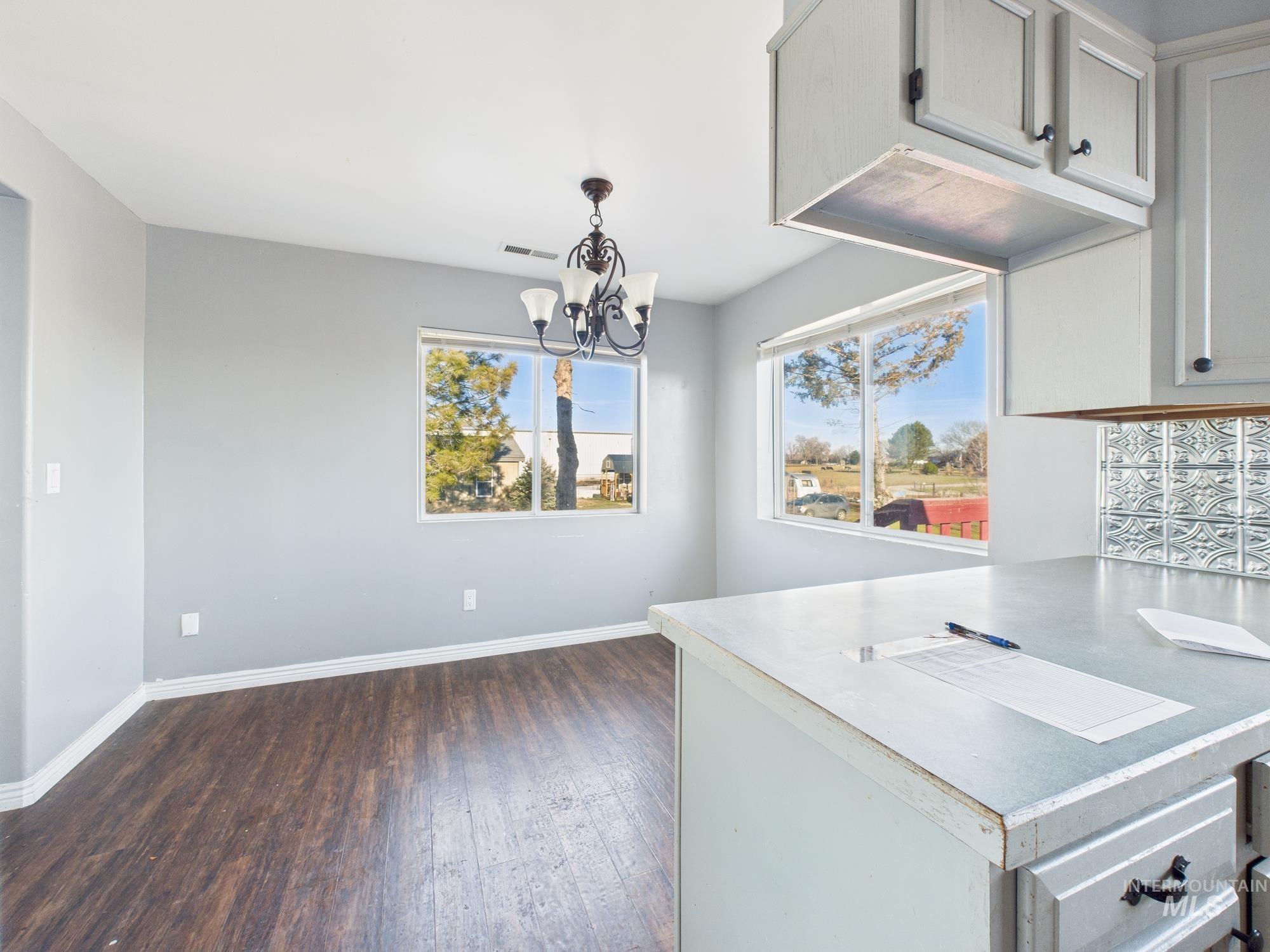 7352 Custer Road Fruitland, ID 83619 - Photo 10 of 43 Kitchen featuring light countertops, a chandelier, dark wood-type flooring, and hanging light fixtures