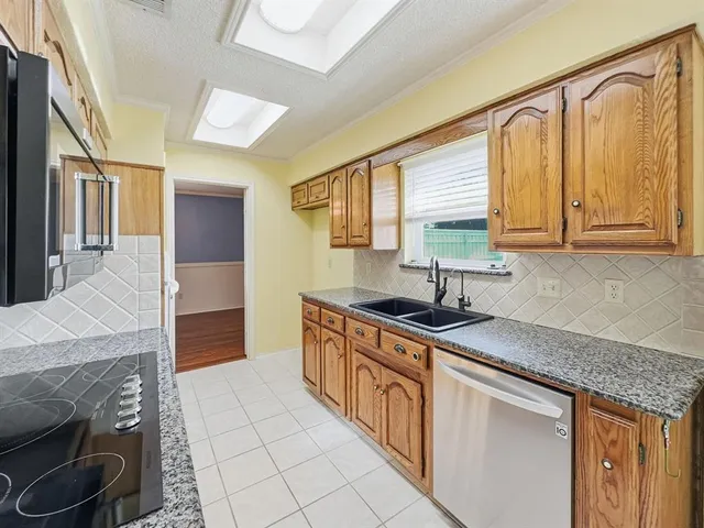 a kitchen with stainless steel appliances granite countertop a sink stove and cabinets
