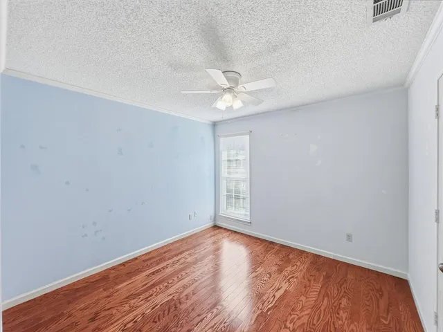 an empty room with a window and a ceiling fan