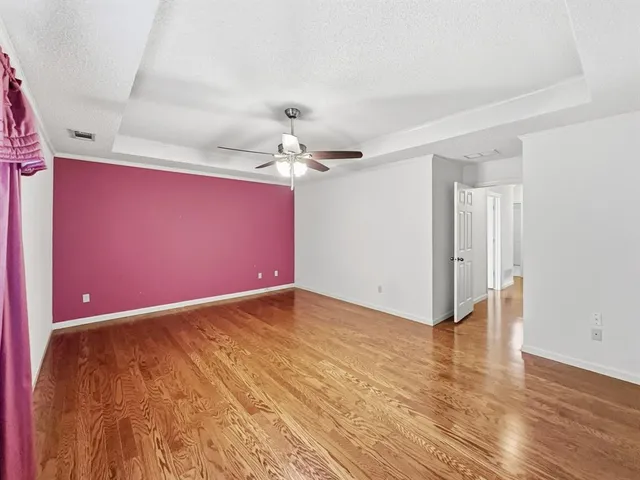 a view of empty room with wooden floor