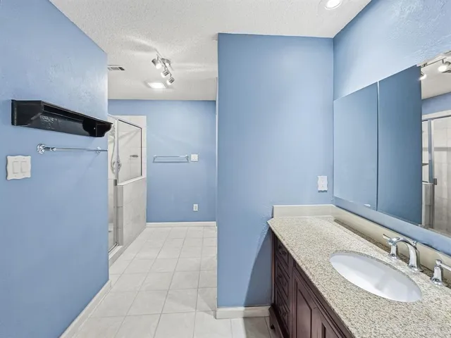 a bathroom with a granite countertop bathtub a sink and a mirror