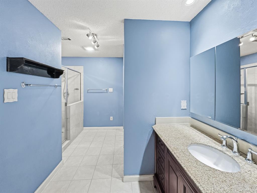 302 Apollo Road Garland, TX 75040 - Photo 24 of 38 a bathroom with a granite countertop bathtub a sink and a mirror