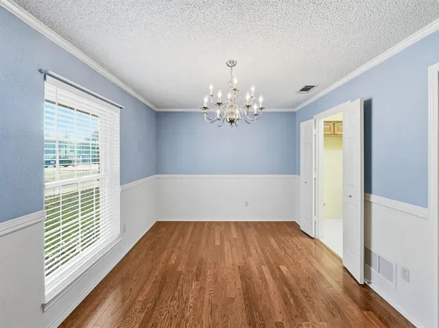 a view of a room with wooden floor and chandelier