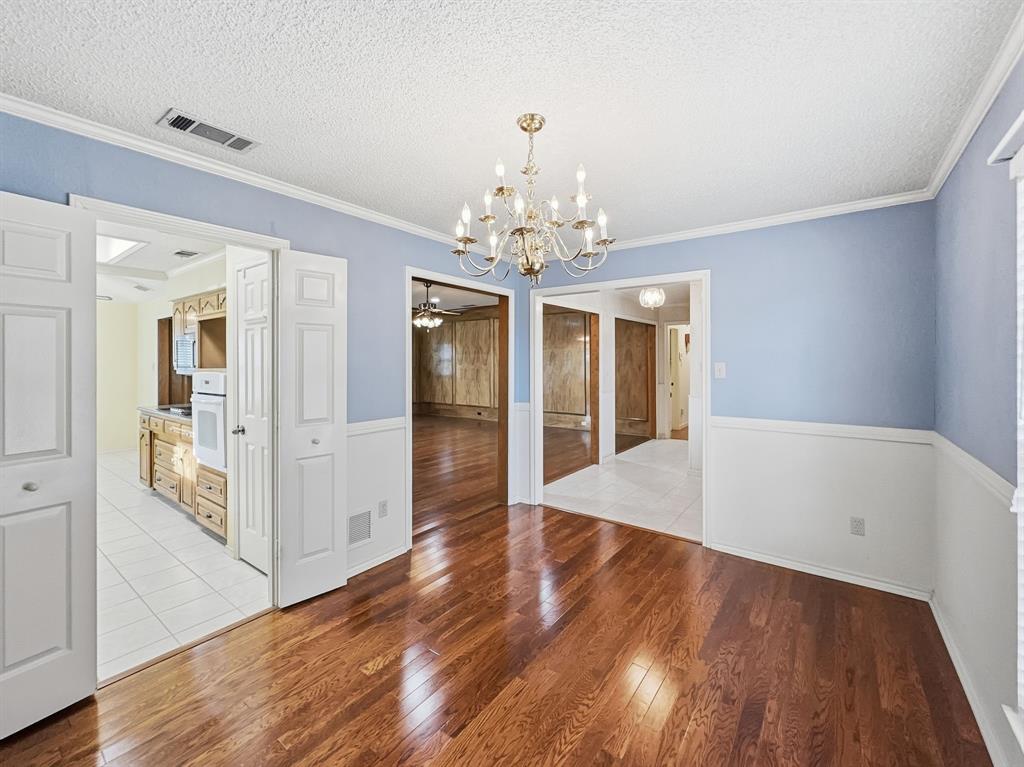 302 Apollo Road Garland, TX 75040 - Photo 7 of 38 a view of a hallway with wooden floor and a chandelier