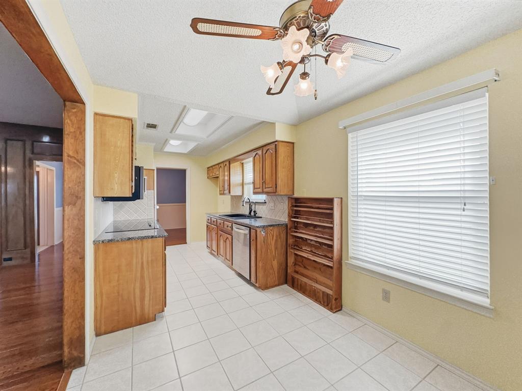 302 Apollo Road Garland, TX 75040 - Photo 9 of 38 a kitchen with a refrigerator and a sink