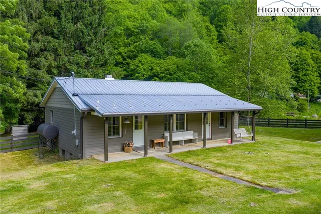a backyard of a house with table and chairs