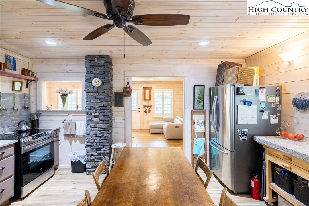1369 Anderson Hill Road Lansing, NC 28643 - Photo 27 of 49 a kitchen with stainless steel appliances kitchen island granite countertop a refrigerator a stove and a sink with wooden floor