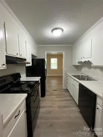 a kitchen with granite countertop a stove sink and cabinets