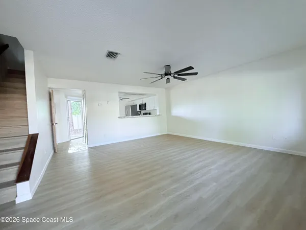 a view of empty room with wooden floor