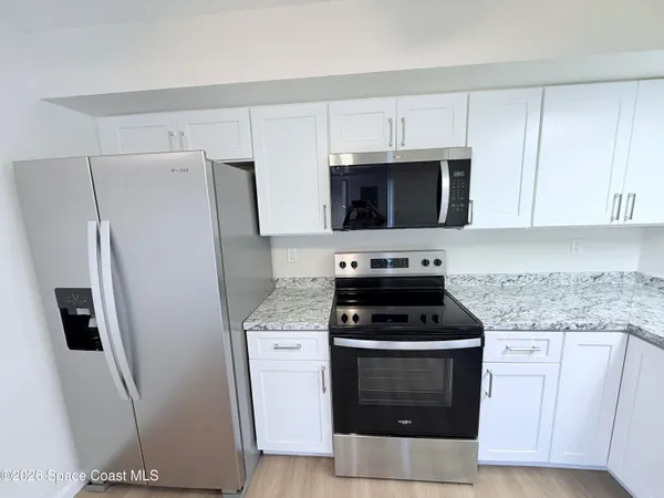 a kitchen with stainless steel appliances a stove microwave and refrigerator