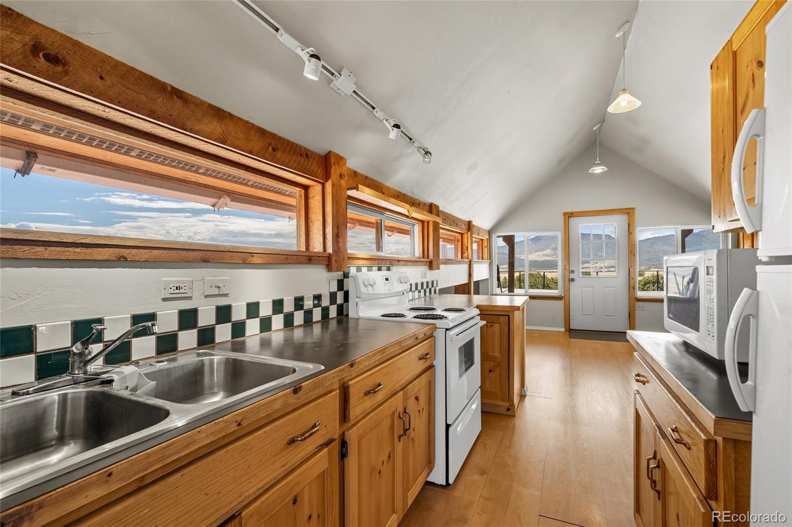 53997 County Rd LL56 Villa Grove, CO 81155 - Photo 20 of 34 a kitchen with stainless steel appliances granite countertop a sink dishwasher stove and refrigerator