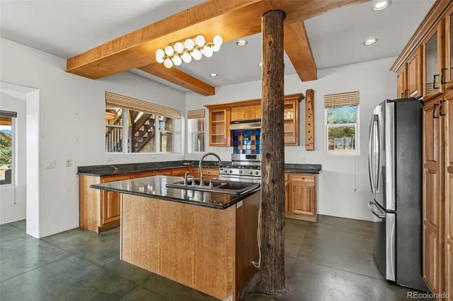 a kitchen with stainless steel appliances granite countertop a refrigerator a stove and a wooden floors