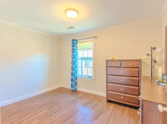 a view of a bedroom with wooden floor