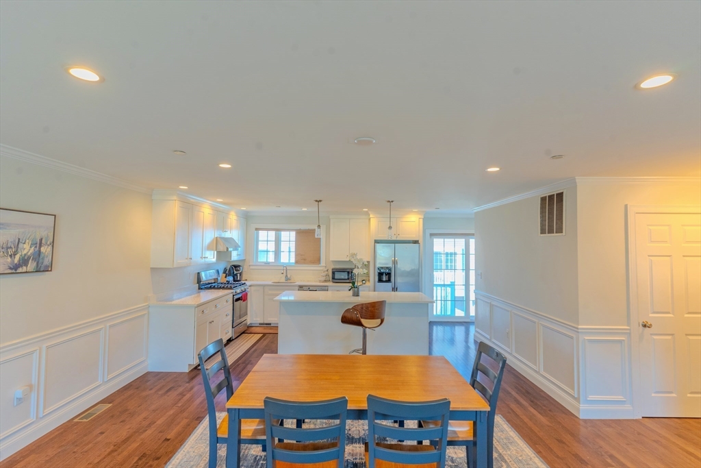2 Mitchell Lane, Unit B Weymouth, MA 02190 - Photo 7 of 31 a view of a kitchen with kitchen island dining table and wooden floor