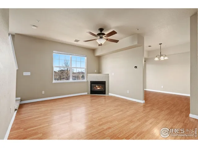 a view of an empty room with a fireplace and a window