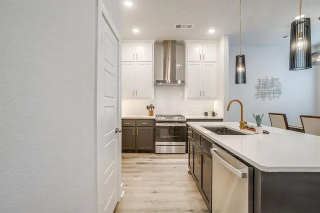 a kitchen with stainless steel appliances granite countertop a sink stove and refrigerator
