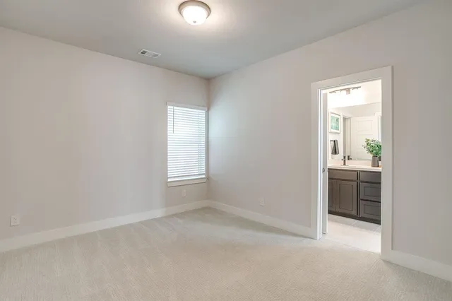 an empty room with a window and a bathroom