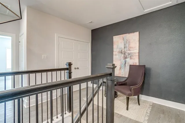 a view of a hallway with wooden floor and a window