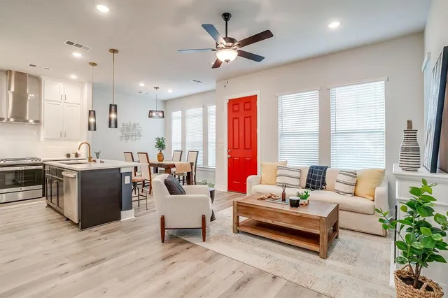 a living room with furniture kitchen view and a large window