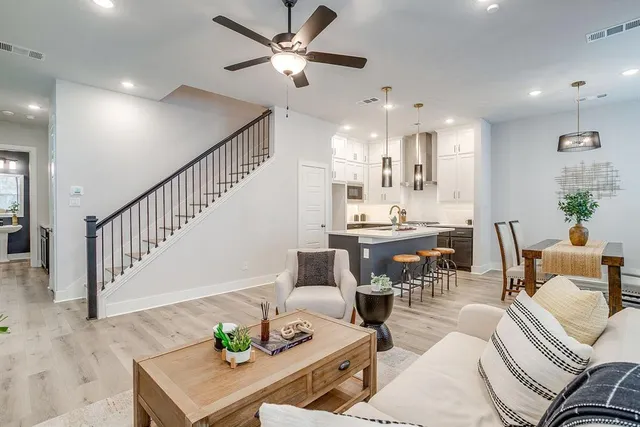 a living room with furniture kitchen view and a chandelier