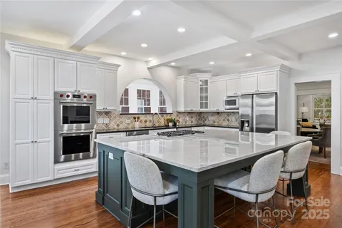 a large kitchen with kitchen island a table and chairs in it