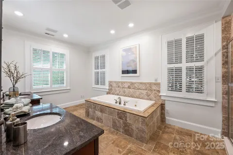 a bathroom with a tub sink and mirror