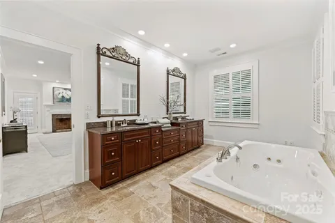 a spacious bathroom with a tub sink and mirror