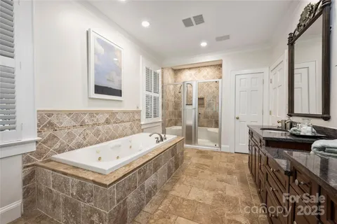 a bathroom with a tub a sink and a mirror