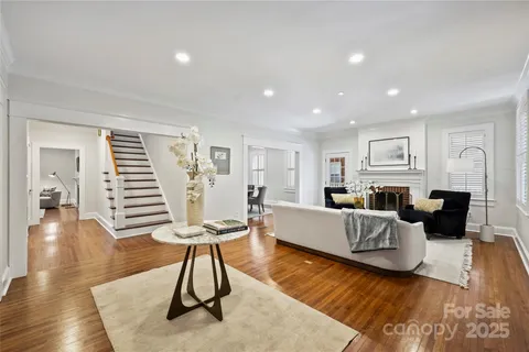 a living room with furniture a wooden floor and a fireplace
