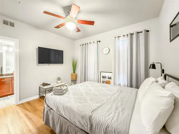 a bedroom with a bed window and a flat screen tv