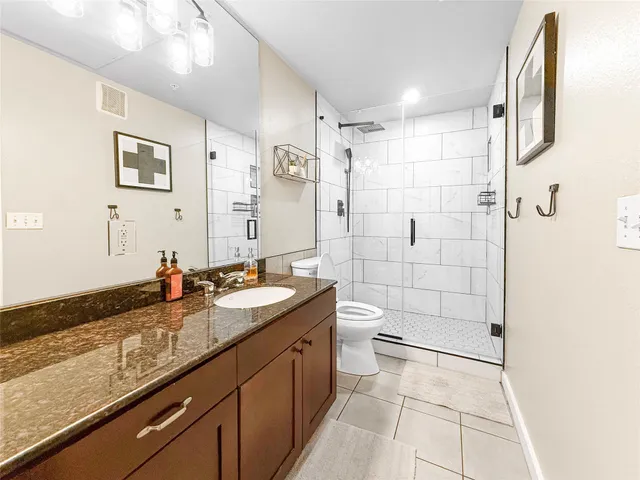 a bathroom with a granite countertop sink mirror and toilet