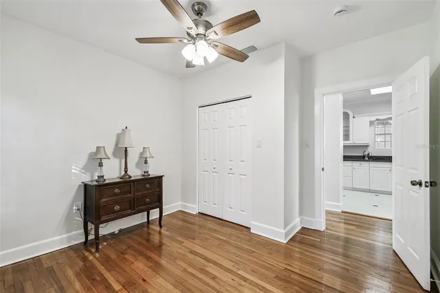 a view of a workspace with wooden floor and a chandelier fan