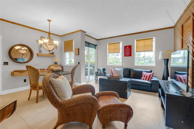 a living room with furniture a chandelier and a large mirror
