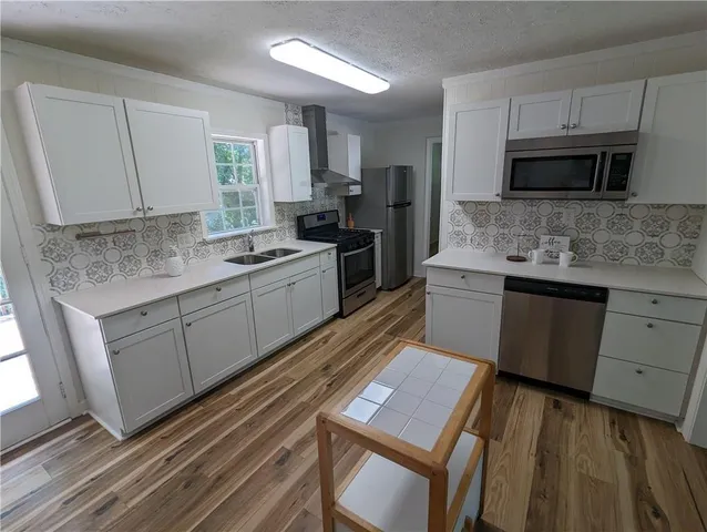 a kitchen with a sink stove and microwave